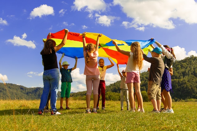 Children of different ages playing in field